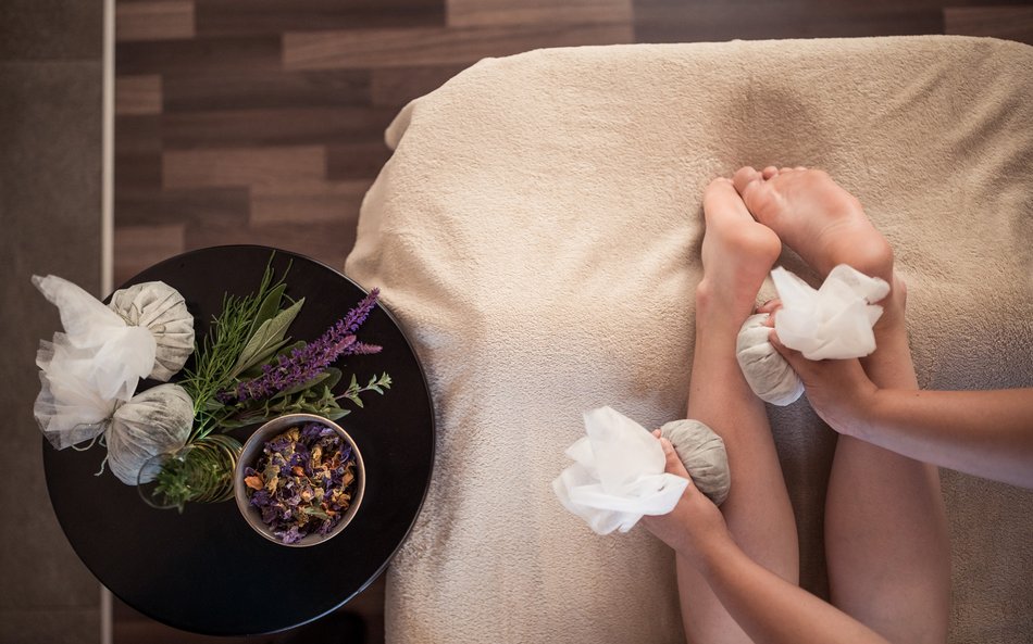 Massage mit Kräuterstempeln