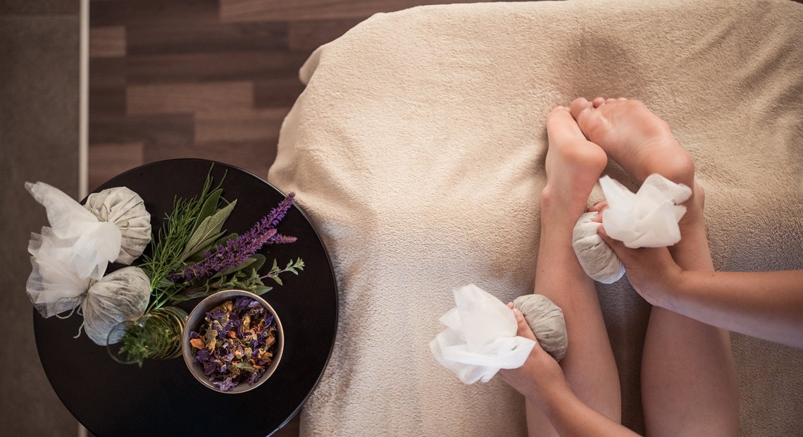 Massage mit Kräuterstempeln